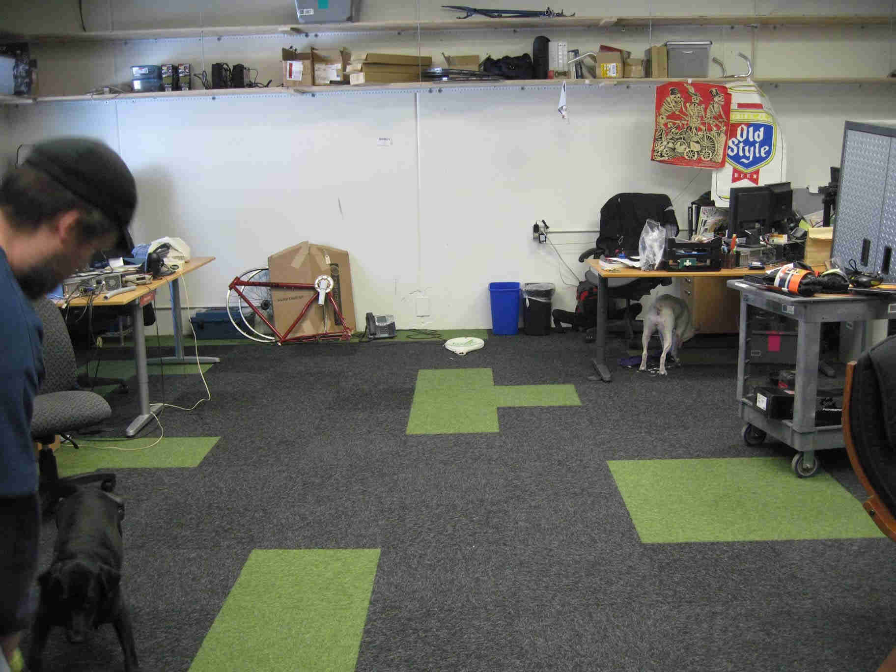 Right side, partial view of a person on the left, with a black dog below, in an office workspace